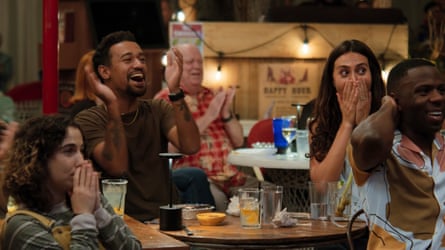 A group of people sat around a table exclaiming at something going on off camera