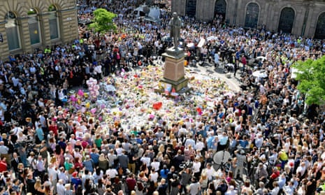 members of the public in St Ann’s Square, Manchester, observe the national minute’s silence on 25 May in remembrance of those who lost their lives in the bombing three days earlier.