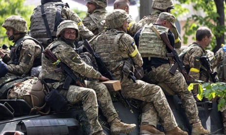 Ukrainian service members ride on top of a military vehicle, amid Russia’s invasion of Ukraine, in Bakhmut, Donetsk region, Ukraine, May 29, 2022