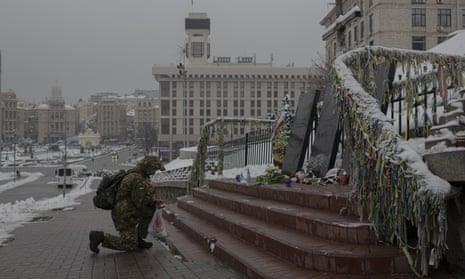 A Ukrainian serviceman kneels in front of a memorial dedicated to people who died in clashes with security forces, at the Independent Square in Kyiv, Ukraine, today.