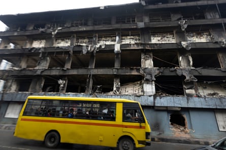 A school bus passes a burnt-out supermarket in Kathmandu
