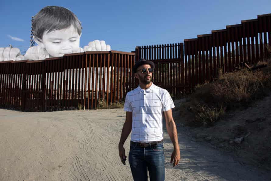 French artist JR pictured near his artwork on the US-Mexico border in Tecate, California, USA.
