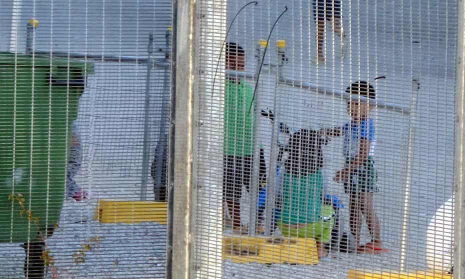 Children playing near a fence at the Australian-run detention centre on Nauru.
