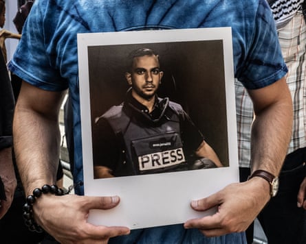 A protester holds a photo of slain Al Jazeera journalist Anas al-Sharif in New York on 16 August.