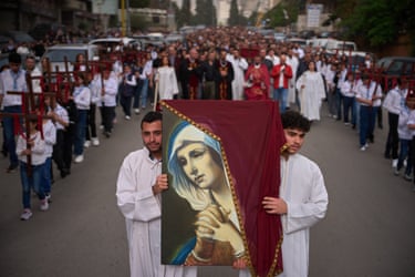 Image 17: The procession holds a picture of the Virgin Mary.