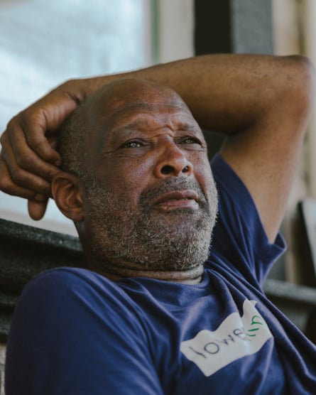 a man in a blue shirt with his hand rested over his head