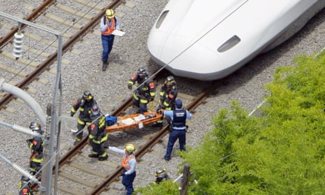Rescue workers take an injured passenger from the bullet train on Tuesday.