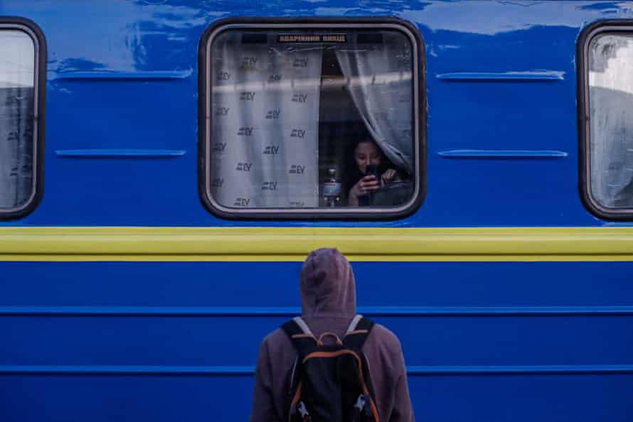 Ukranian journalist Illia video chats with her girlfriend through the train window as he sees her off in Dnipro on Victory Day.