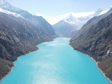 A lake surrounded by mountains covered in snow at the peaks