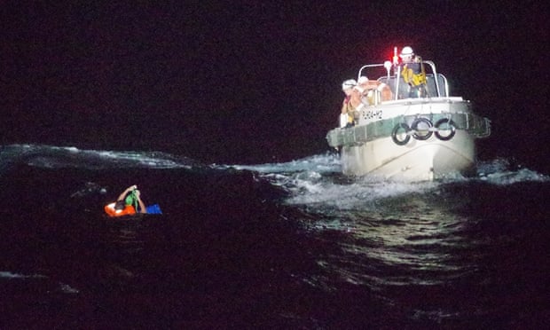 A Filipino crew member of a Panamanian ship carrying thousands of cows is rescued by the Japanese coast guard members near Amami Ōshima island last month.