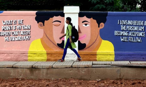 A woman walks past a painting to raise mental health awareness on a wall in Bangalore, India, in September 2019. 