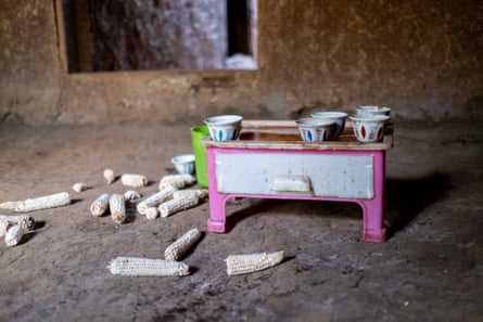 Some cups of coffee on a small table, with some discarded maize husks on the floor. 