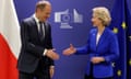 Ursula von der Leyen reaches out to shake hands with Donald Tusk, who is offering up his hand