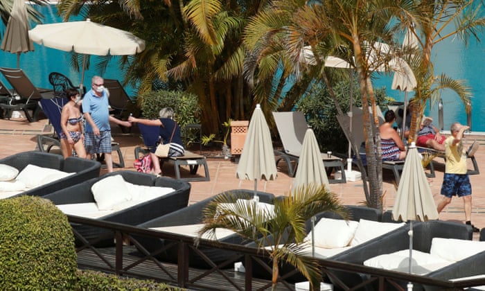 Tourists with masks near the pool of H10 Costa Adeje Palace, which is on lockdown after cases of coronavirus were confirmed.