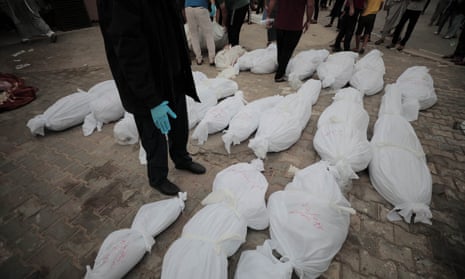 The shrouded bodies of Palestinians killed in the latest Israeli attacks on central Gaza, lie outside the Al-Aqsa Martyrs Hospital in the city of Deir Al-Balah.