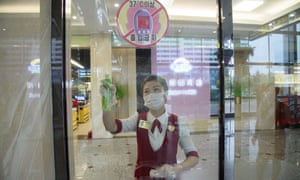 A cashier sprays disinfectant onto a window as part of preventative measures against Covid-19, in the Daesong Department Store in Pyongyang on September 27, 2021.