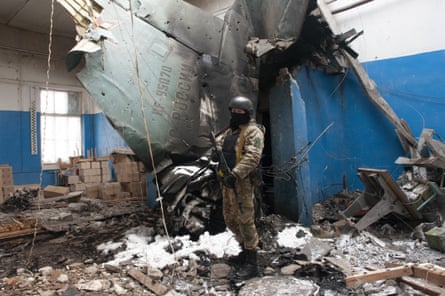 Ukrainian serviceman stands next to the vertical tail fin of a Russian Su-34 bomber lying in a damaged building in Kharkiv, Ukraine, Tuesday, March 8