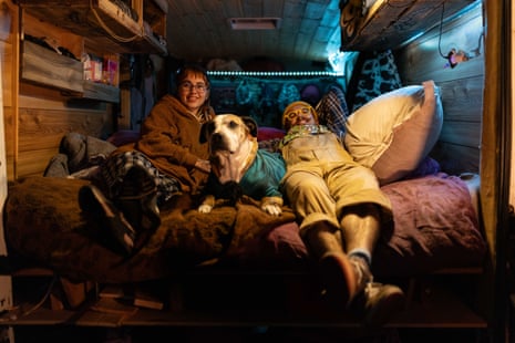 Two people in a cosy setup in a van with a dog