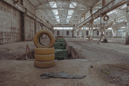 A warehouse with piles of tyres, hanging tyres and dug-out pits and other obstacles