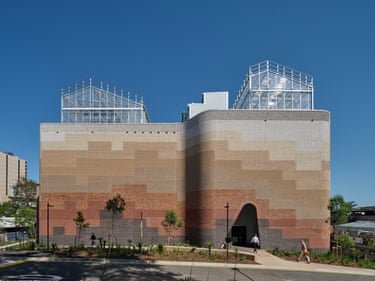 Plant Futures Facility building with patchwork brick facade and glass rooftop structures under blue sky