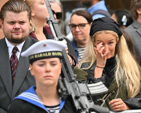 A woman reacts as she waits before the casket of late King Harald V of Norway is transferred during a royal procession from the Royal Palace Chapel to the Cathedral in Oslo.