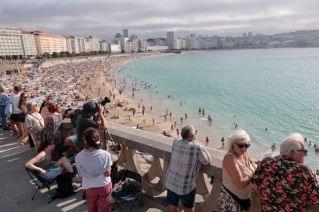 People wait for a solar eclipse at the beach in A Coruna, Spain