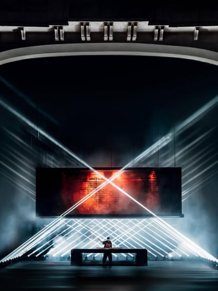 Alok performs on stage backed by lasers and a giant box of screens