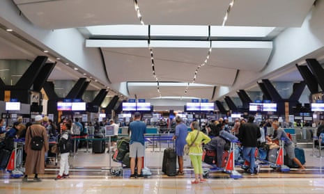 Travellers queue at a check-in counter at OR Tambo International Airport in Johannesburg on 27 November 27, 2021, after several countries banned flights from South Africa.