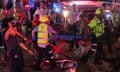Paramedics in hi vis evacuate one of the injured people on a stretcher