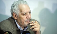 Khaled Nezzar, smoking a cigarette behind microphones at a press conference in January 2016