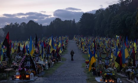 A man walks in the Field of Mars military cemetery after sunrise as Ukraine marks Defenders Day, honouring soldiers who died fighting Russia's ongoing invasion, in Lviv, Ukraine, October 1, 2023.