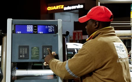 An attendant operates a pump at a TotalEnergies petrol station