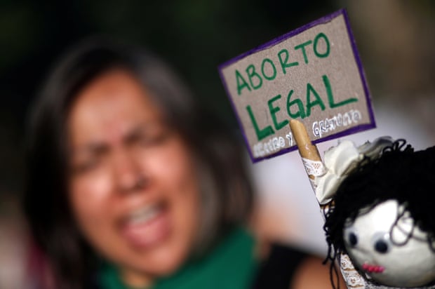 A woman protests next to a sign that reads ‘Legal abortion’