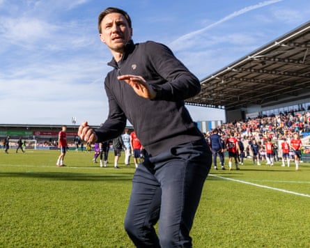 The York manager, Stuart Maynard, celebrates in front of the fans after their victory.