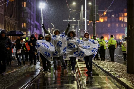 People wait in the rain ahead of the New Year’s celebrations in Edinburgh.