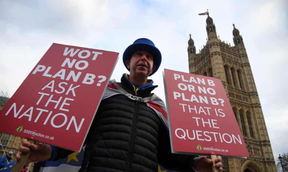 A man holds signs reading 'Plan B or no Plan B? That is the question' outside parliament.