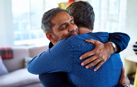 Two middle-aged men sharing a warm hug