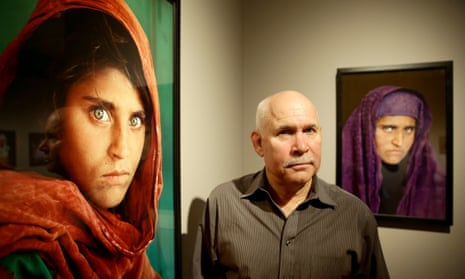 Steve McCurry next to Afghan Girl, 1984, with his portrait of Sharbat Gula, taken nearly two decades later, in the background.