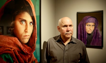 Photographer Steve McCurry next to his photos of Sharbat Gula at an exhibition in Hamburg, Germany, in 2013.