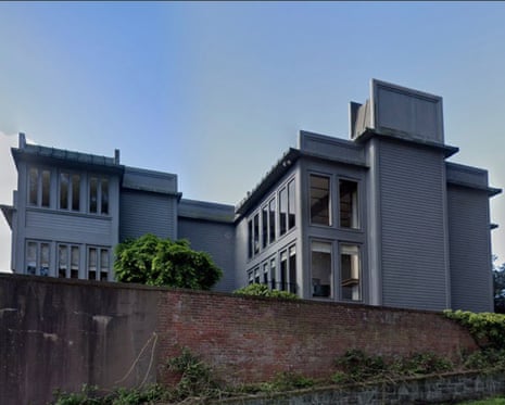 A large grey mansion with many windows sits behind a brick wall in San Francisco