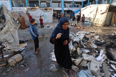 A Palestinian woman reacts as she checks the damages after an Israeli strike hit a school sheltering displaced Palestinians in the Al-Bureij camp in the central Gaza Strip on 8 July 2025.
