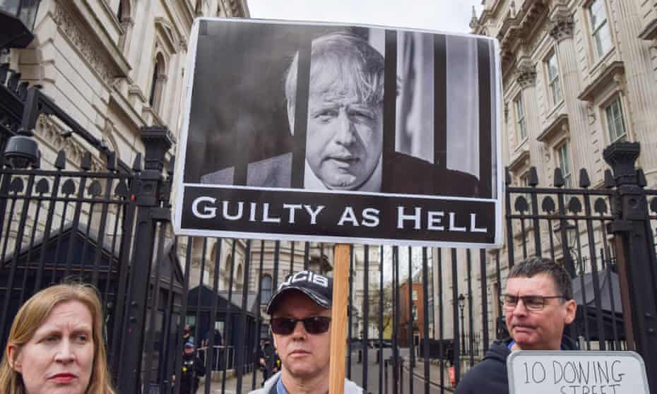 Protesters outside Downing Street hold a 'guilty as hell' sign with a picture of Boris Johnson