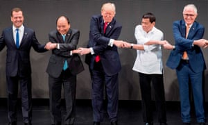 From left: Russia’s prime minister Dmitry Medvedev, Vietnam’s prime minister Nguyen Xuan Phuc, Donald Trump, Rodrigo Duterte and Australian PM Malcolm Turnbull join hands for a summit photo in Manila.