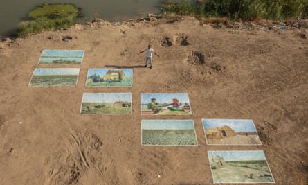 Photographer Haider Hamid exposes his pictures on the banks of the Tigris River under al- Sarrefiya Bridge in Baghdad.