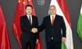 Viktor Orbán and Wang Xiaohong shake hands in front of Chinese and Hungarian flags