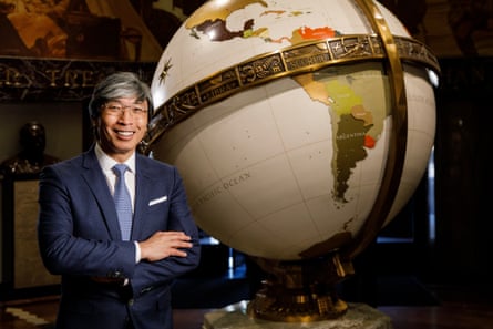 man stands next to globe