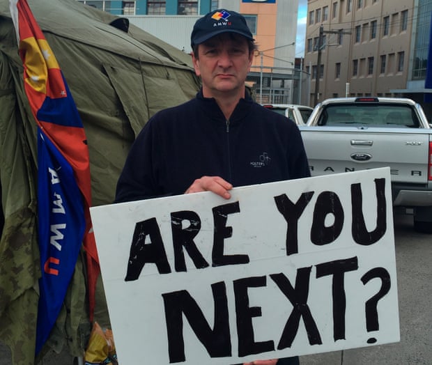 Fletch, a worker at a Carlton United Breweries depot in Victoria, Australia is protesting against new conditions with a sign reading, “Are you next?”