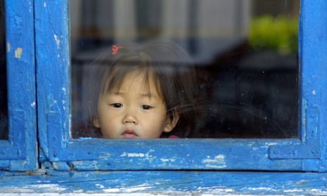 A North Korean child peers through a window in Hyangsan province.
