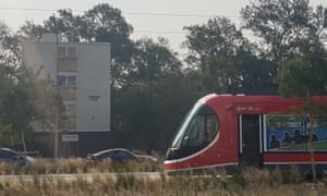 A tram glides by public housing flats in Canberra