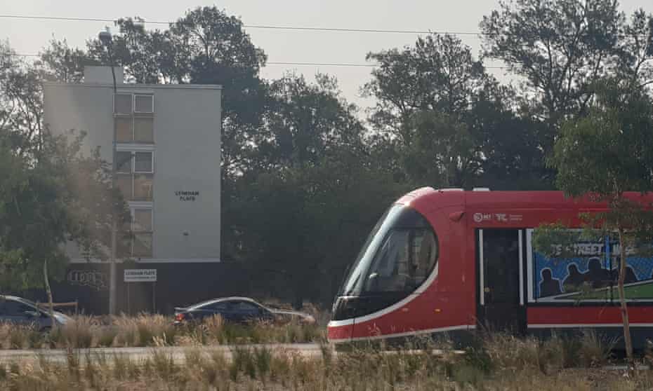 A tram glides by public housing flats in Canberra